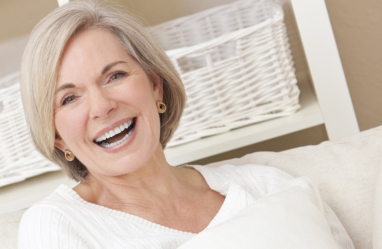 older woman relaxing on her couch at home