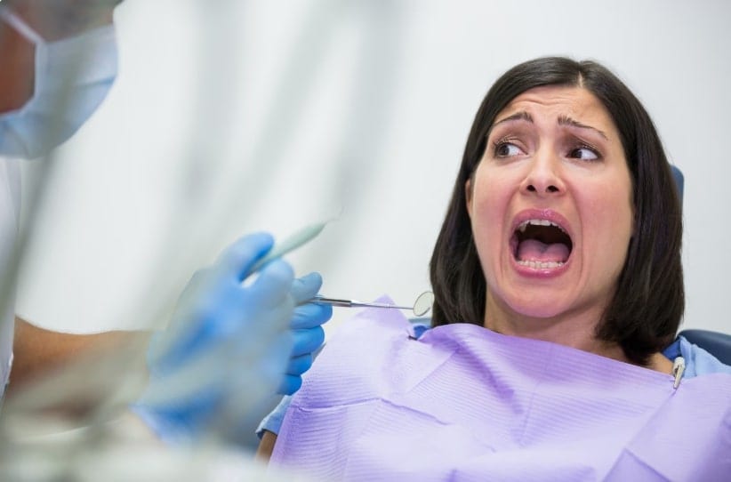 Woman with a fearful expression during a dental check-up