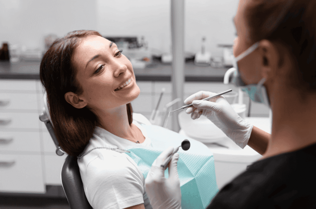 Female dentist examining a smiling patient’s teeth