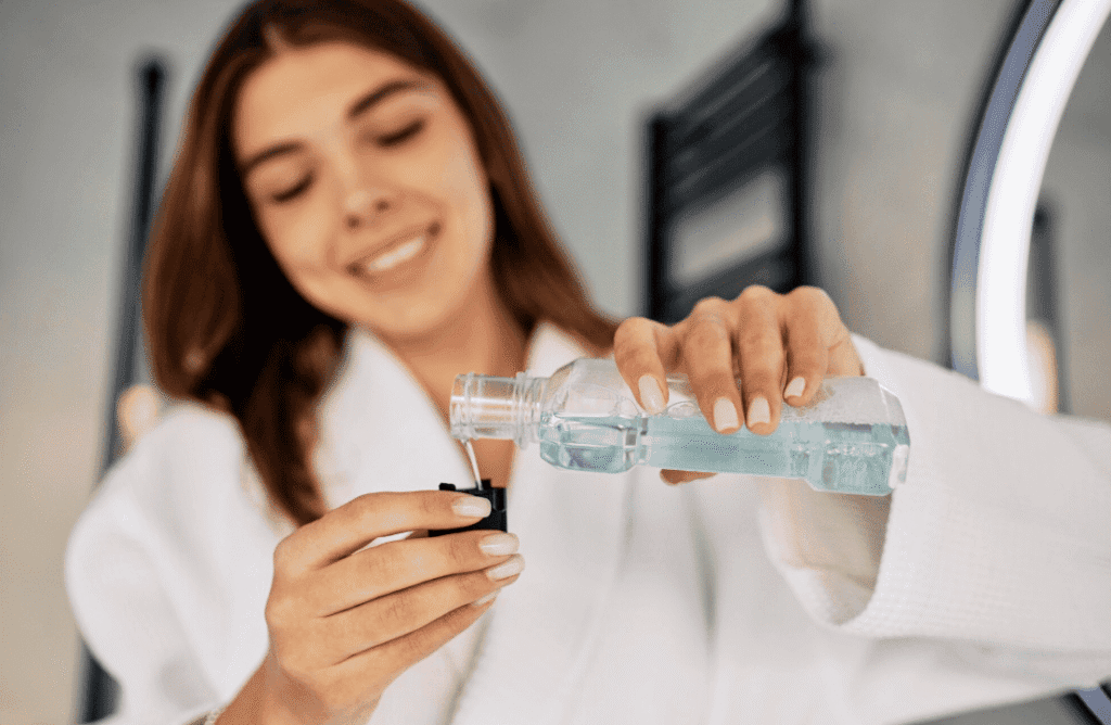 Woman pouring mouthwash into a small cap